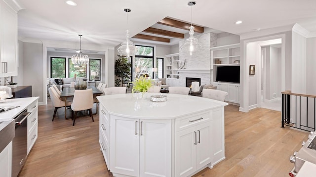 kitchen with dishwasher, open floor plan, a large fireplace, and light wood finished floors