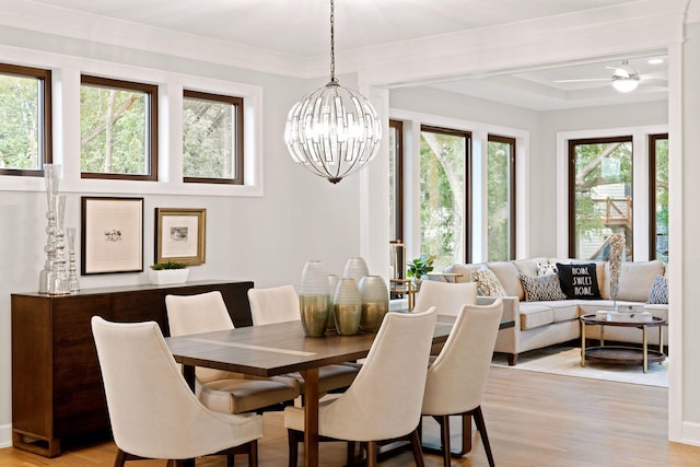 dining area featuring crown molding, light wood-style floors, and a chandelier