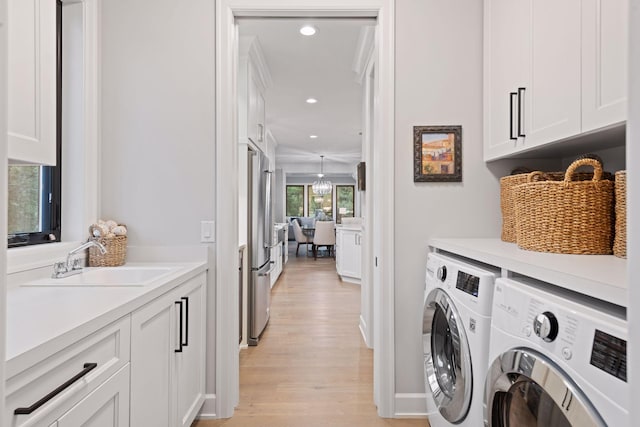laundry room featuring independent washer and dryer, light wood finished floors, recessed lighting, a sink, and cabinet space