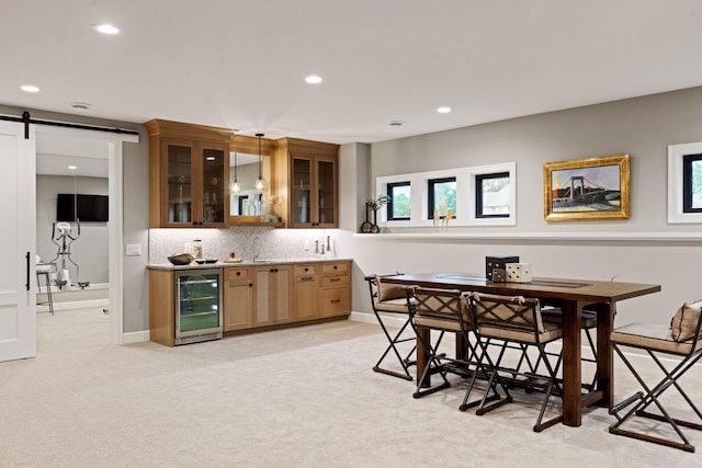 dining room with wet bar, wine cooler, light carpet, a barn door, and recessed lighting