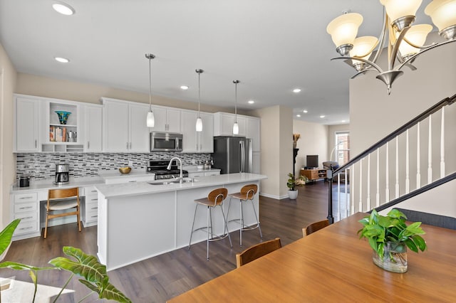 4025 River Valley Way, Eagan, MN 55122 - kitchen with appliances with stainless steel finishes, a sink, an island with sink, tasteful backsplash, and light countertops