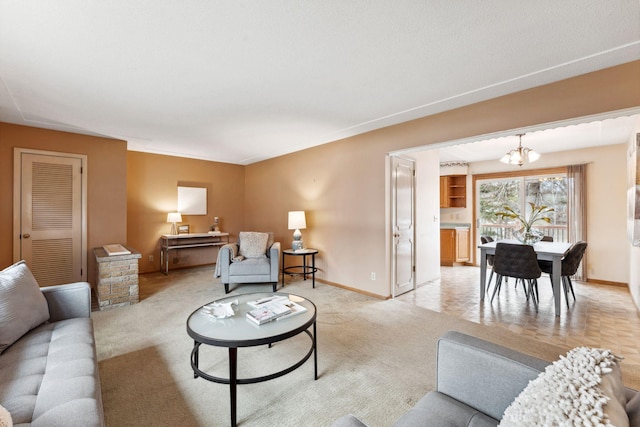 living room featuring a chandelier, light carpet, and baseboards