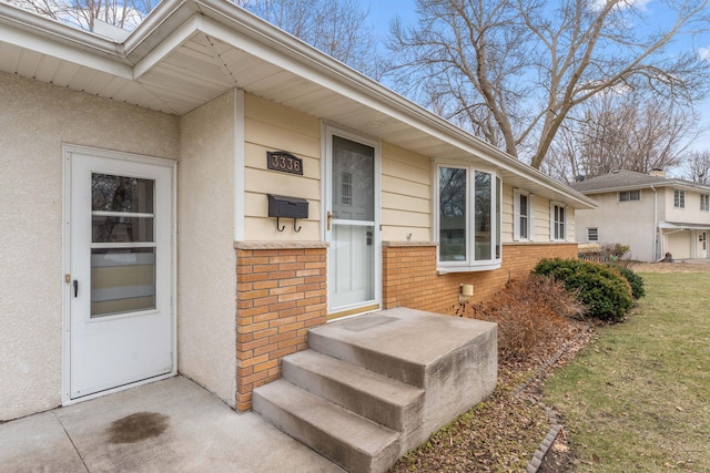 property entrance featuring brick siding and stucco siding