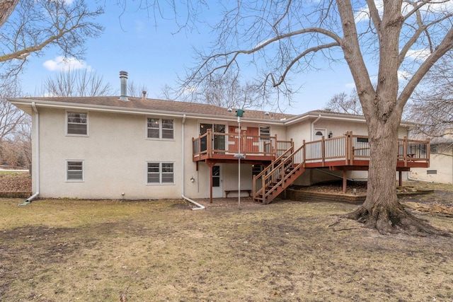 back of house featuring stairs, a deck, stucco siding, and a yard