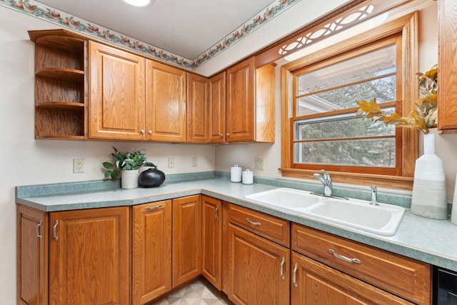 kitchen with a sink, light countertops, open shelves, and brown cabinets