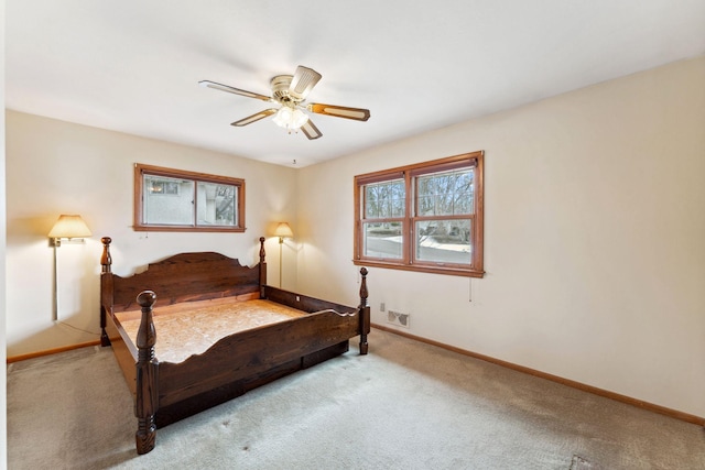 carpeted bedroom featuring baseboards, a ceiling fan, and visible vents