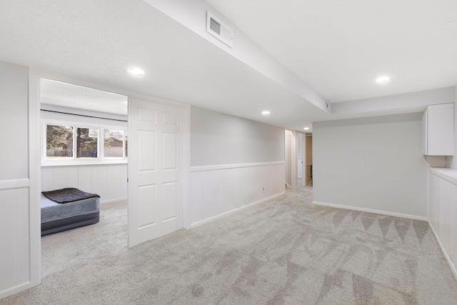 below grade area with visible vents, recessed lighting, and light colored carpet