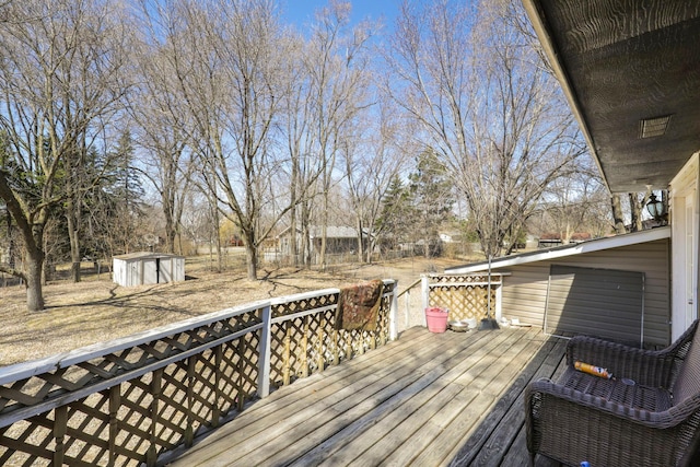 wooden deck featuring a shed and an outbuilding