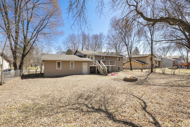 rear view of house featuring a fenced backyard, stairway, a fire pit, and a wooden deck