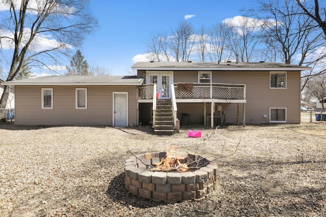 back of house featuring stairs, a fire pit, and a wooden deck