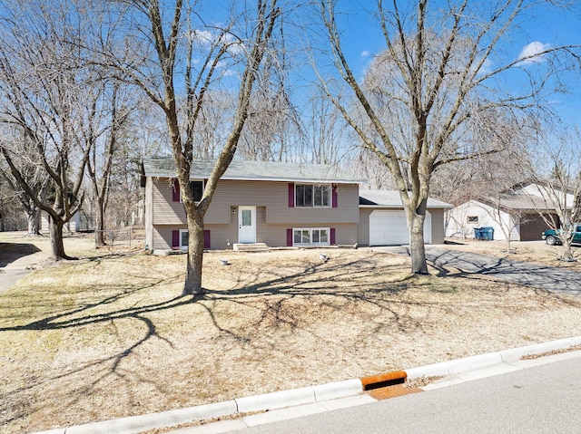 raised ranch with concrete driveway and a garage