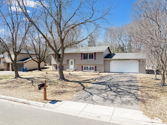 bi-level home featuring a garage and driveway