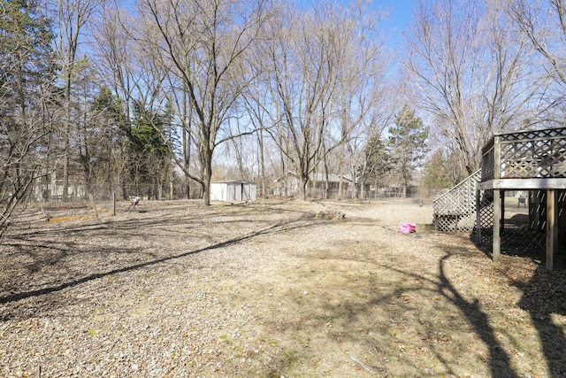 view of yard with a shed, fence, an outdoor structure, and stairs