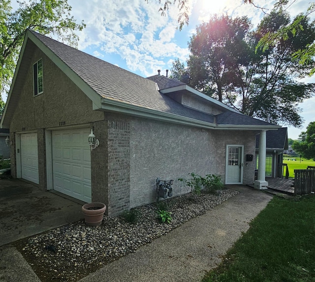 2208 10th Ave SE Unit 12, Willmar, MN 56201 - view of side of property with stucco siding, roof with shingles, and a garage