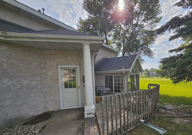 2208 10th Ave SE Unit 12, Willmar, MN 56201 - view of exterior entry featuring stucco siding, a lawn, and roof with shingles