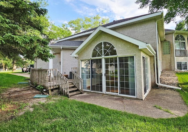 2208 10th Ave SE Unit 12, Willmar, MN 56201 - back of house with stucco siding and a yard