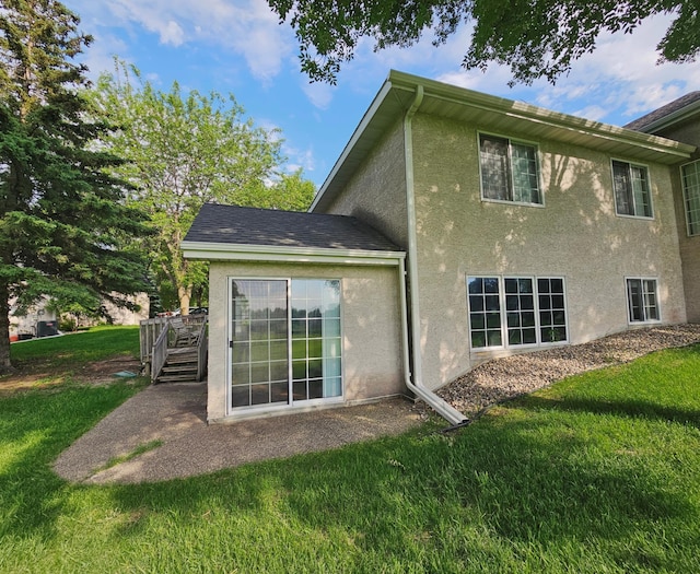 2208 10th Ave SE Unit 12, Willmar, MN 56201 - back of property featuring stucco siding, a yard, and a wooden deck