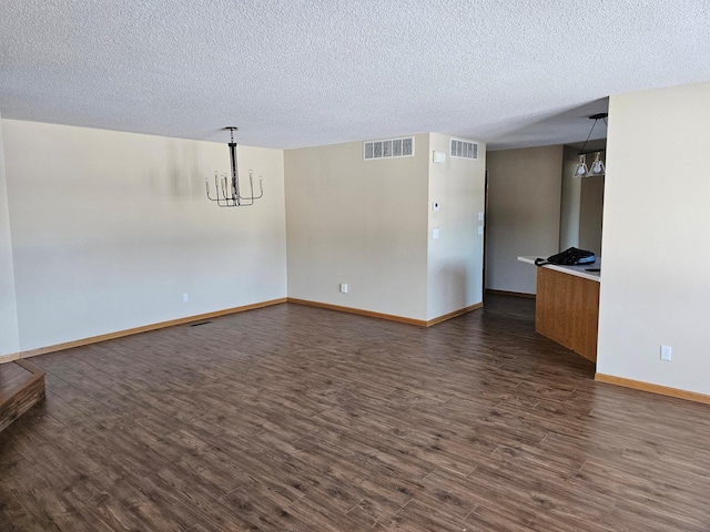 2208 10th Ave SE Unit 12, Willmar, MN 56201 - unfurnished living room with a chandelier, dark wood finished floors, and a textured ceiling