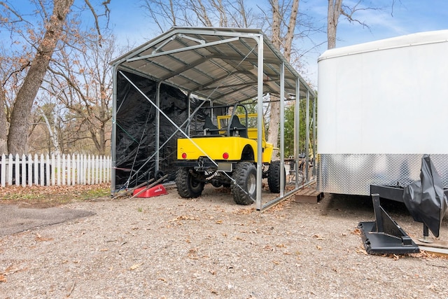 view of outbuilding with a detached carport and fence