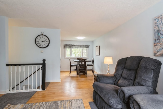 living room with baseboards and light wood-type flooring