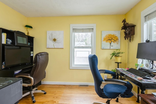 office featuring visible vents, wood finished floors, and baseboards