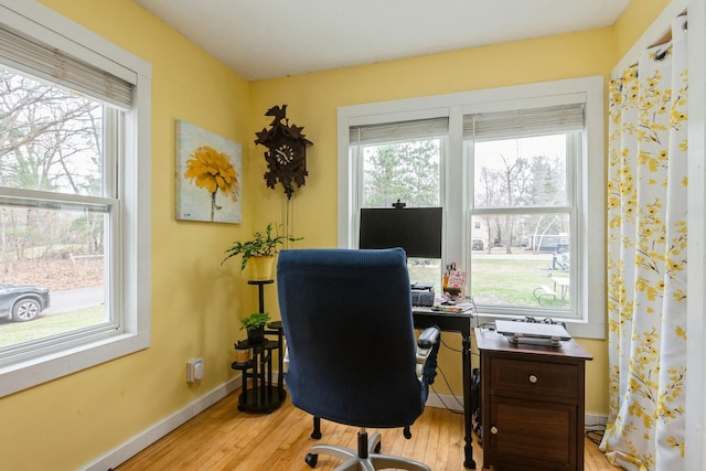 office space featuring baseboards, wood finished floors, and plenty of natural light