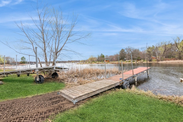 dock area with a yard and a water view