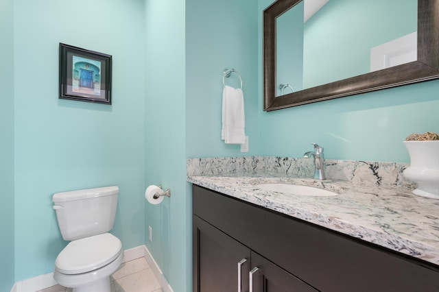 bathroom featuring tile patterned flooring, vanity, toilet, and baseboards
