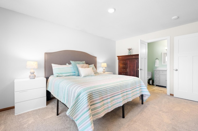 bedroom featuring recessed lighting, light carpet, ensuite bathroom, and baseboards