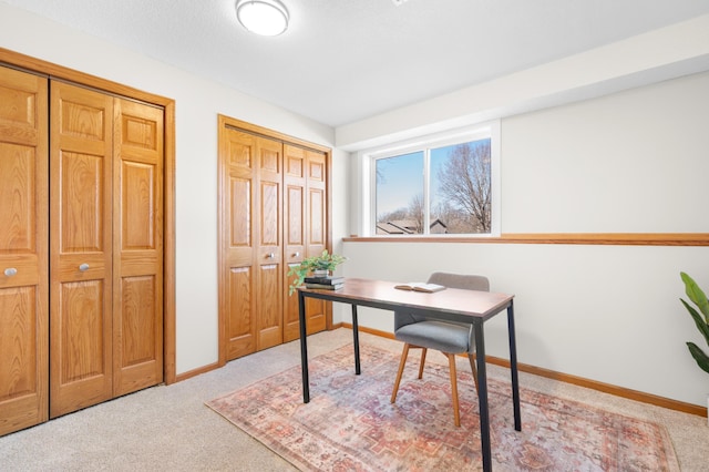 office area with light carpet and baseboards
