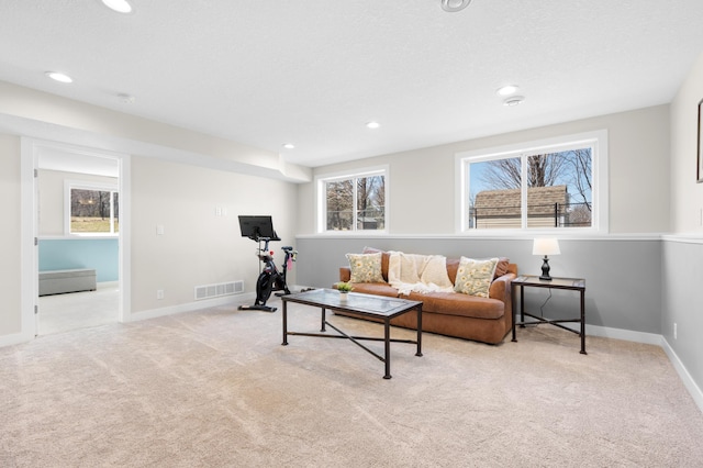 living area with recessed lighting, visible vents, and carpet