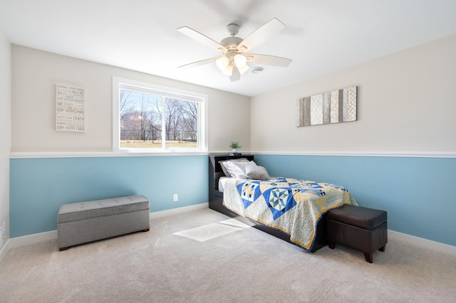carpeted bedroom with ceiling fan and baseboards