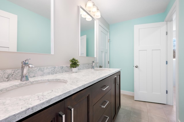 full bath featuring tile patterned flooring, baseboards, a sink, and double vanity