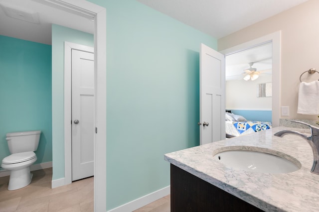 ensuite bathroom with a sink, double vanity, toilet, ensuite bathroom, and baseboards
