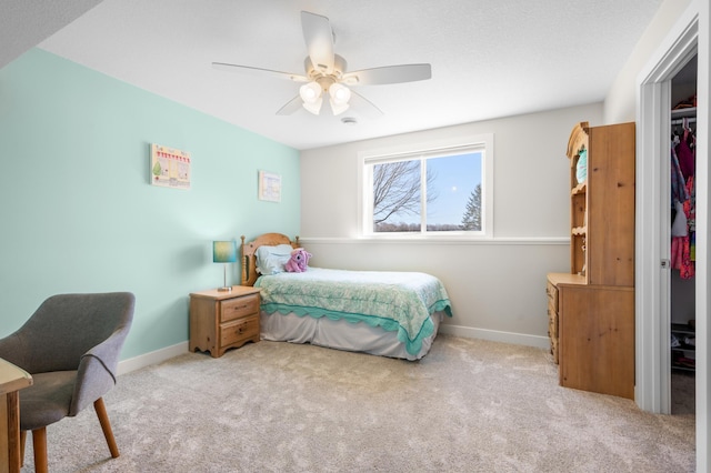 carpeted bedroom featuring ceiling fan, baseboards, and a closet
