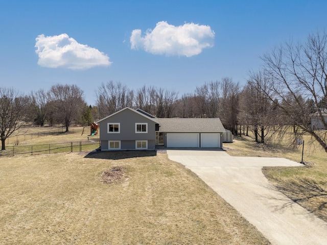 view of front facade featuring fence, a front yard, driveway, and a garage