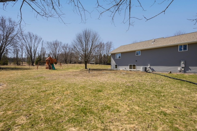 view of yard with fence, cooling unit, and a playground