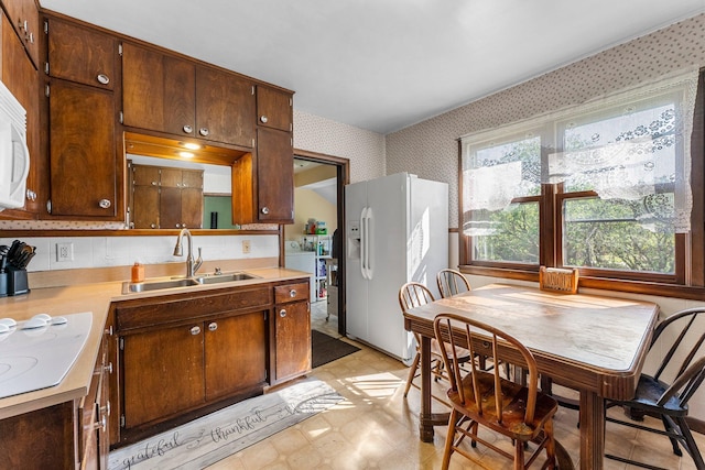 100 Stark Rd, Harris, MN 55032 - kitchen with wallpapered walls, white fridge with ice dispenser, a sink, light floors, and light countertops