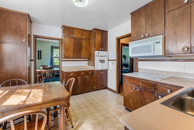 100 Stark Rd, Harris, MN 55032 - kitchen featuring wallpapered walls, white appliances, light floors, light countertops, and a sink