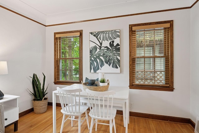dining space featuring light wood finished floors and baseboards