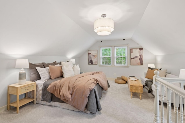 carpeted bedroom with vaulted ceiling and baseboards