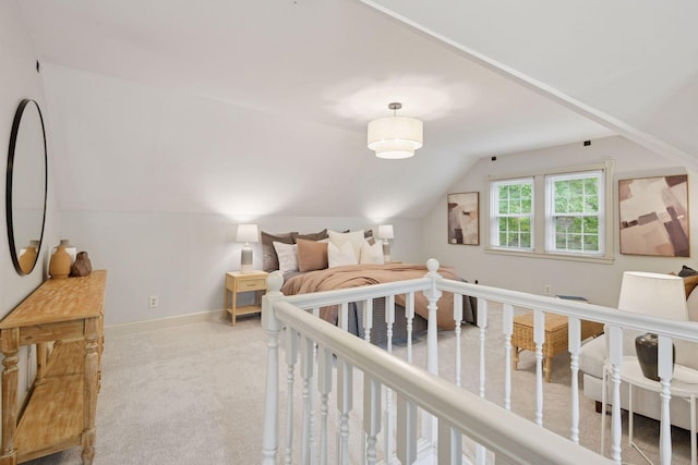 carpeted bedroom featuring lofted ceiling and baseboards