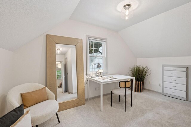 office space featuring lofted ceiling, light carpet, healthy amount of natural light, and baseboards