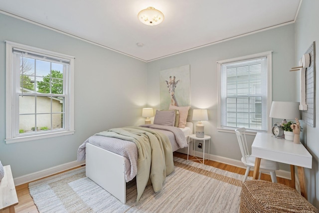 bedroom featuring light wood finished floors and baseboards