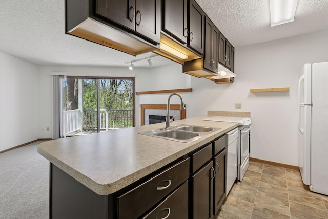 kitchen featuring white appliances, a textured ceiling, baseboards, and a sink