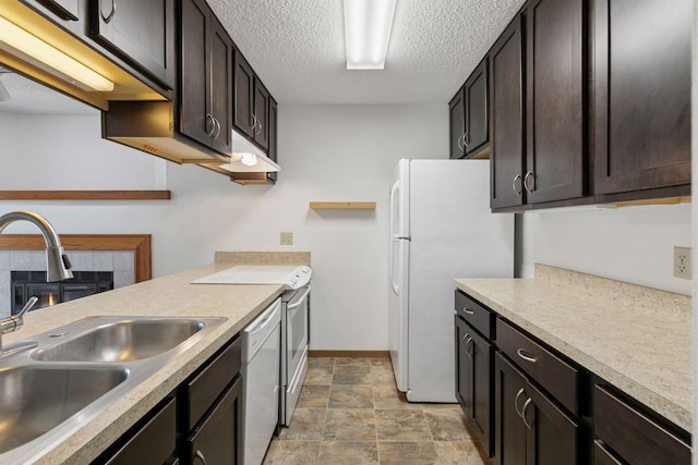 kitchen with dark brown cabinetry, a sink, white appliances, light countertops, and a textured ceiling