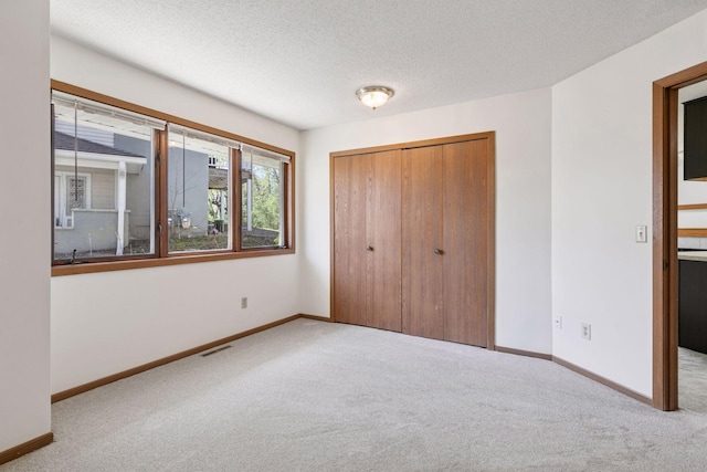 unfurnished bedroom with carpet, a closet, and visible vents