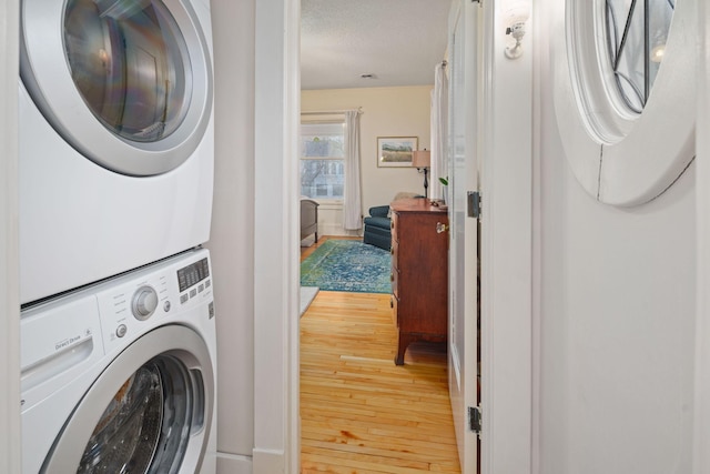 1767 Fremont Ave S, Minneapolis, MN 55403 - laundry room featuring stacked washer / dryer, wood-type flooring, and a textured ceiling