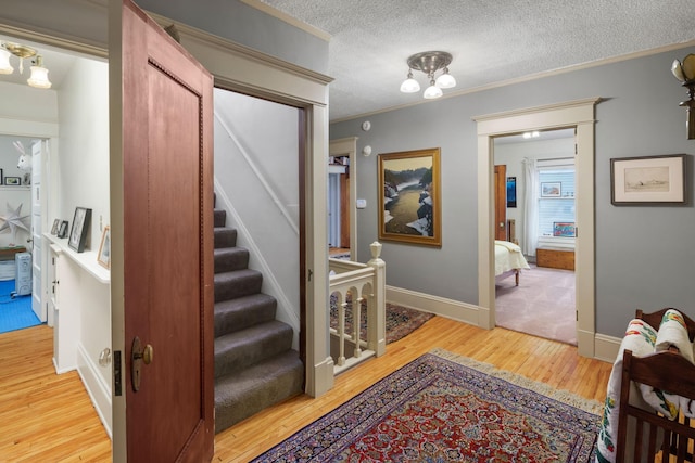 1767 Fremont Ave S, Minneapolis, MN 55403 - staircase with wood finished floors, a textured ceiling, and crown molding