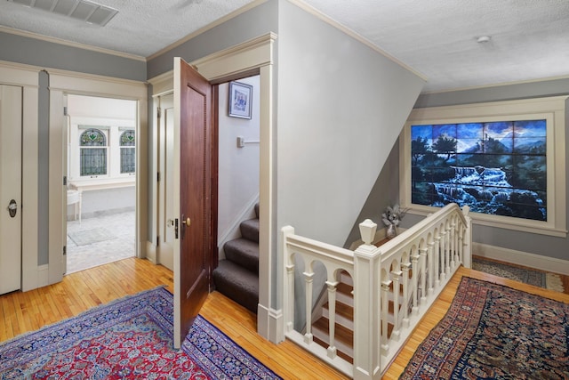 1767 Fremont Ave S, Minneapolis, MN 55403 - stairway featuring hardwood / wood-style floors, a textured ceiling, and crown molding